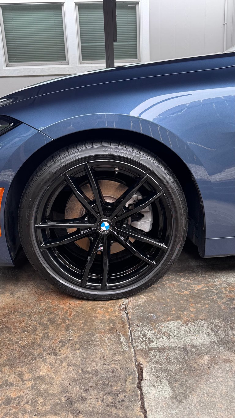Close-up of detailed blue car wheel with black alloy rim and tire after complete reset detail in Tampa FL